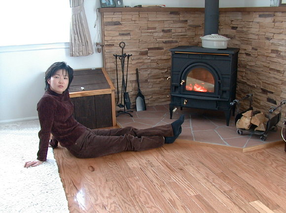 PHOTO: Mitsue-san beside the wood stove.